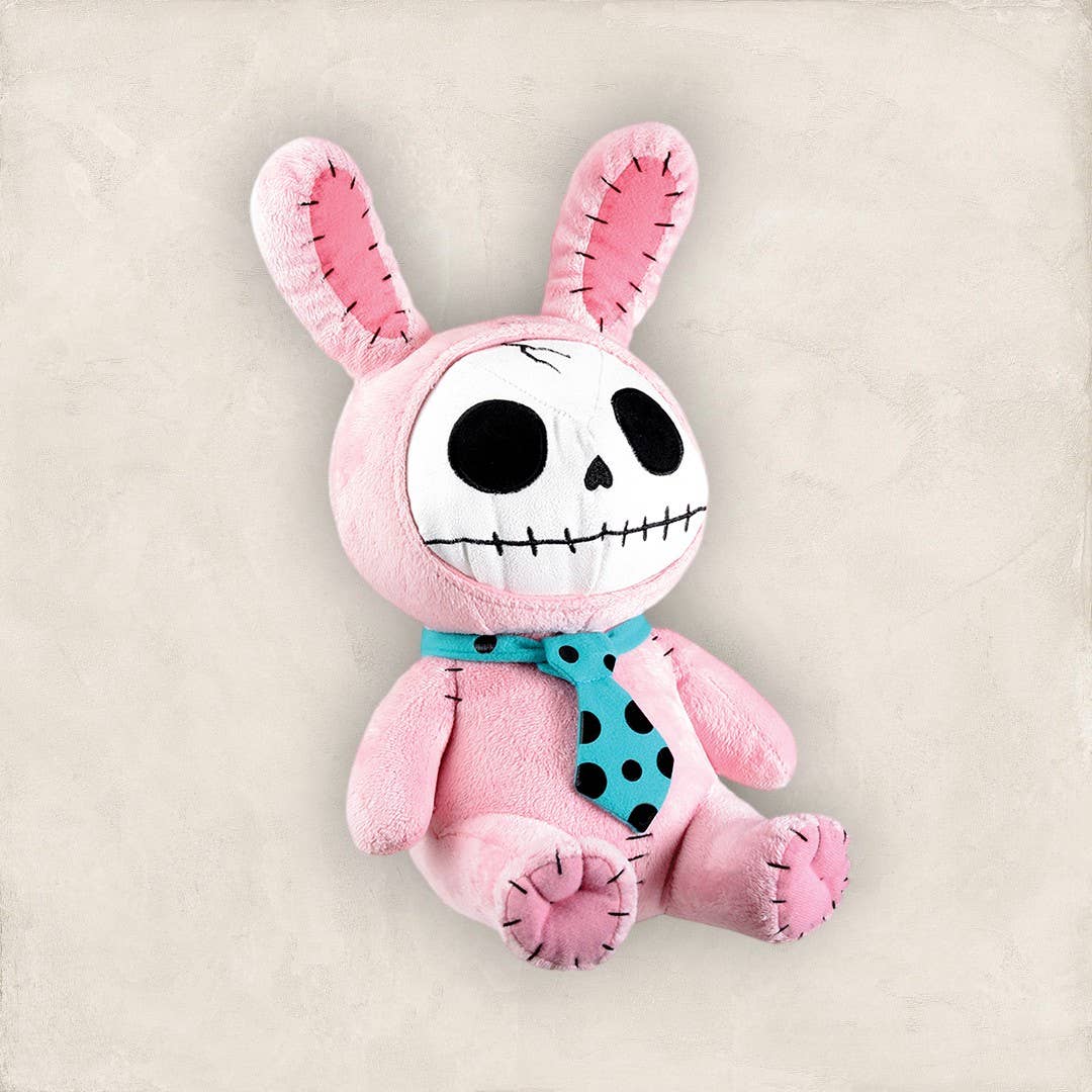 Pink plush bunny with skull face, stitched black eyes and mouth, wearing blue polka-dot scarf.