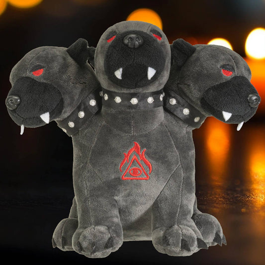 Dark gray Cerberus plush with three heads, red eyes, fangs, studded collar, and red emblem on chest.